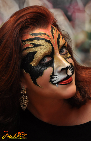 red haired woman in a painted on tiger mask
